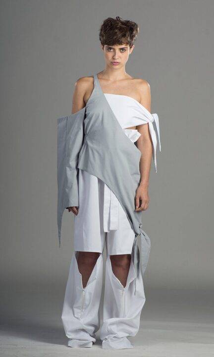 Una modelo presenta un atuendo de moda contemporánea en tonos grises y blancos.