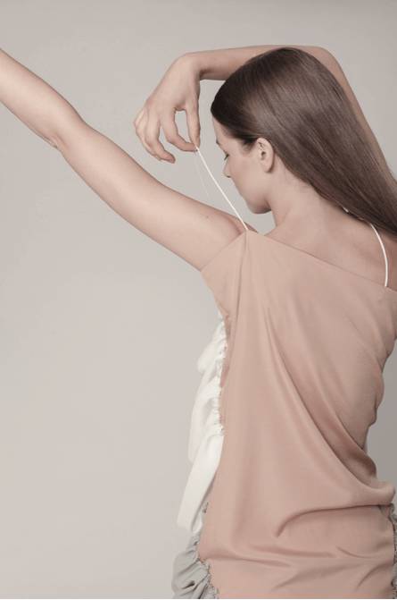 Una modelo posando de espaldas con un atuendo elegante y moderno.
