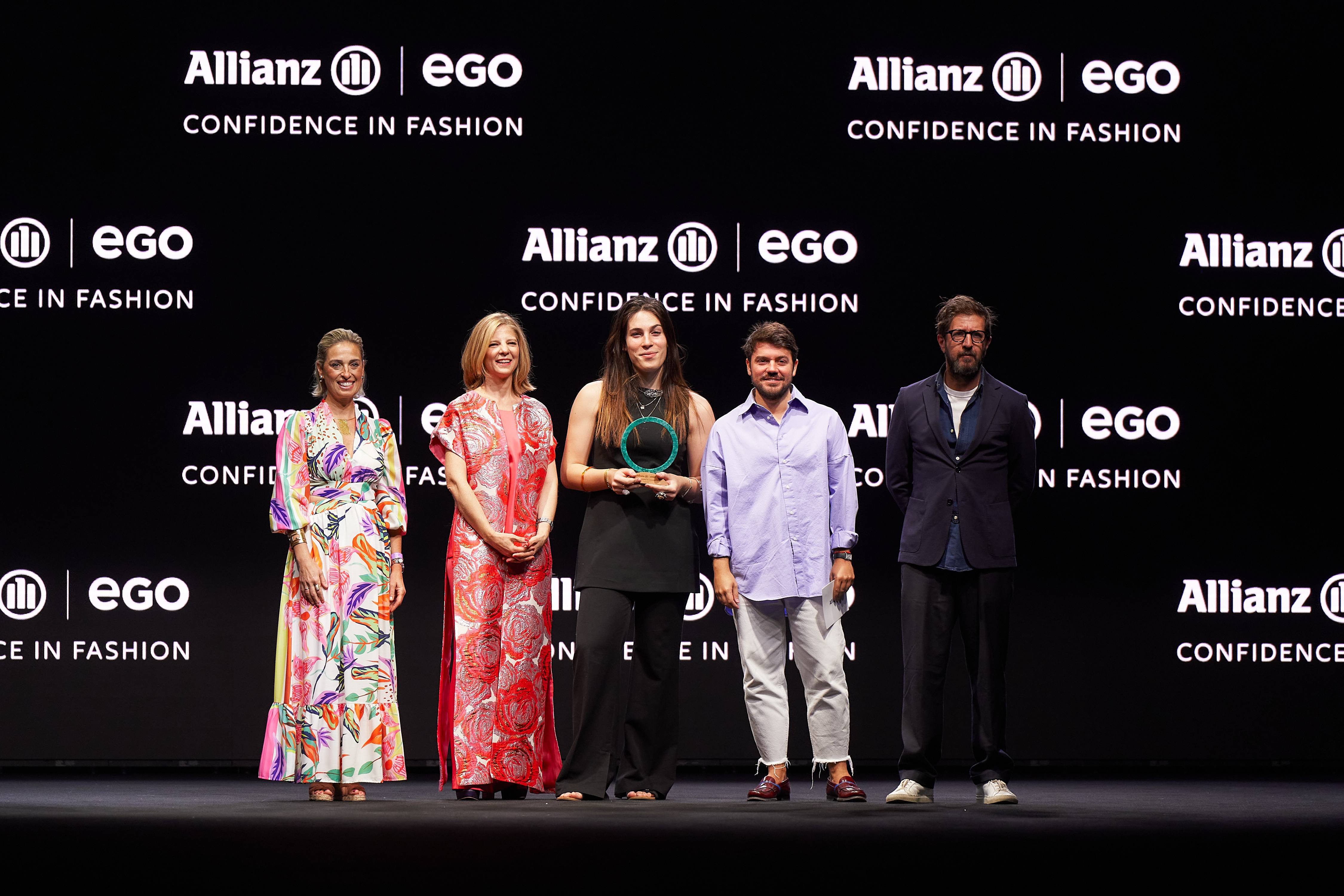 Un grupo de cinco personas posan en un evento de moda con un telón de fondo que muestra el logo de Allianz y Ego.