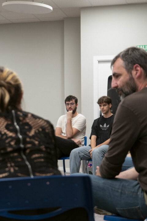 Un grupo de personas sentadas en círculo durante una conversación.