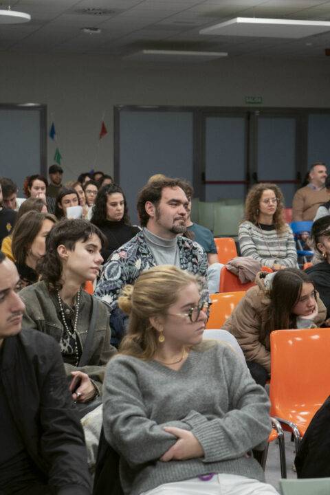 Un grupo de personas sentadas, escuchando atentamente en un evento o conferencia.