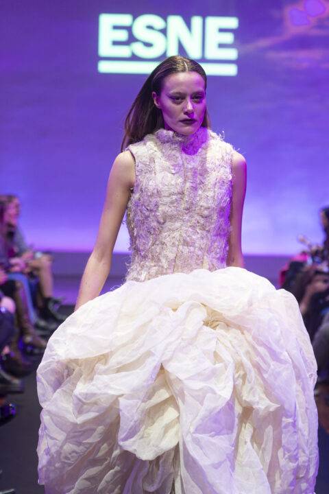 Una modelo presenta un vestido original en una pasarela de moda.