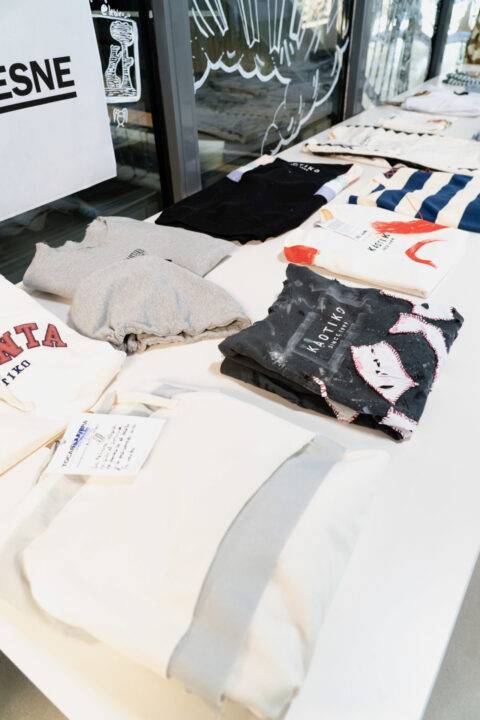 Una mesa con varias prendas de vestir dobladas y exhibidas.