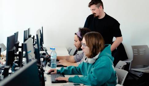 Un grupo de personas trabajando en ordenadores en un ambiente de oficina.