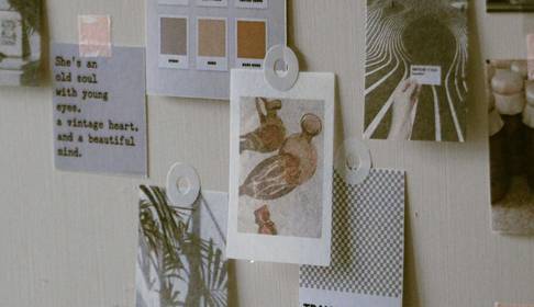 Una pared decorada con varios documentos y muestras de color, creando una estética artística.