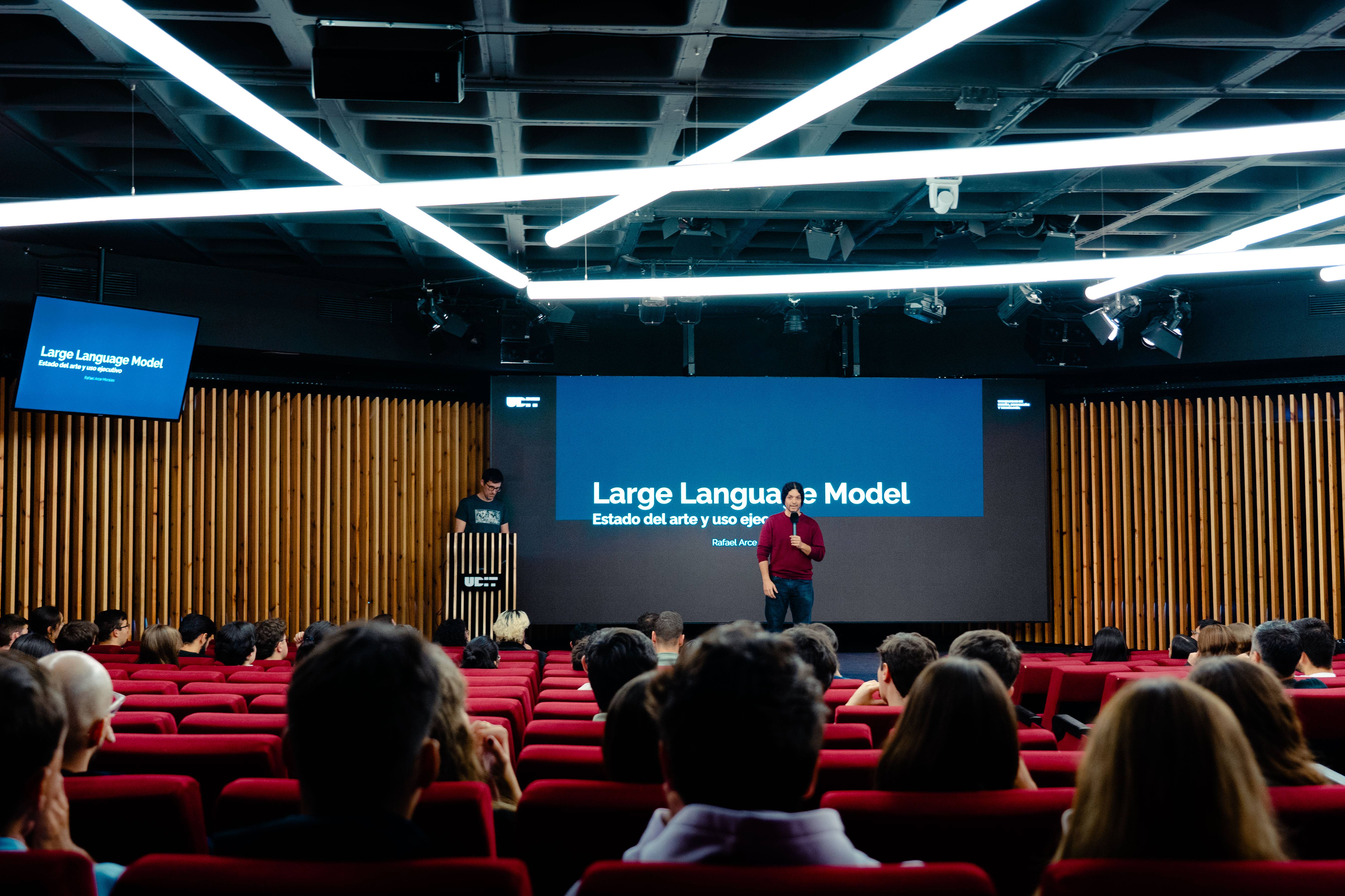 Una presentación sobre modelos de lenguaje en un auditorio en el auditorio de UDIT