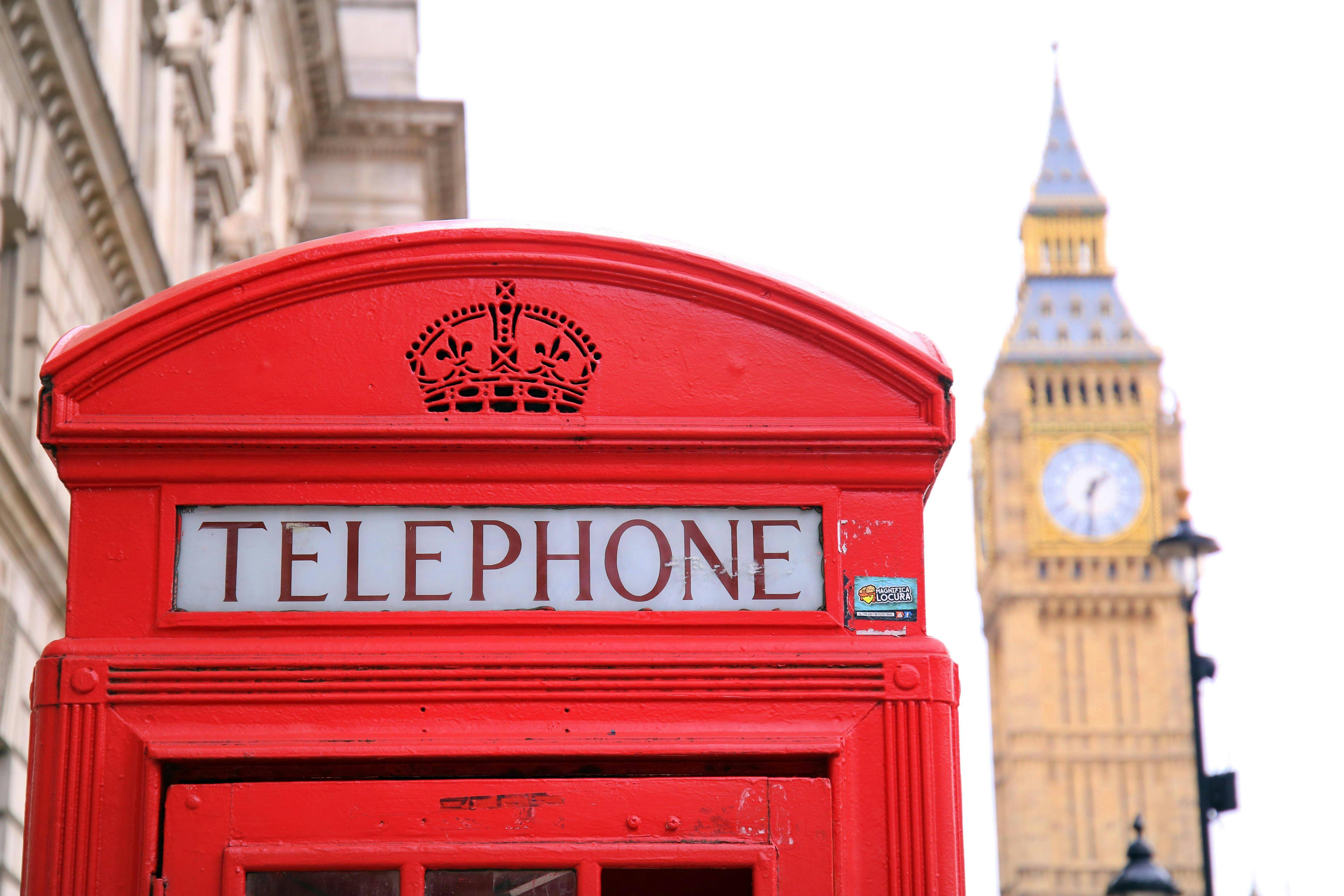 Cabina telefónica roja en Londres con el Big Ben al fondo.