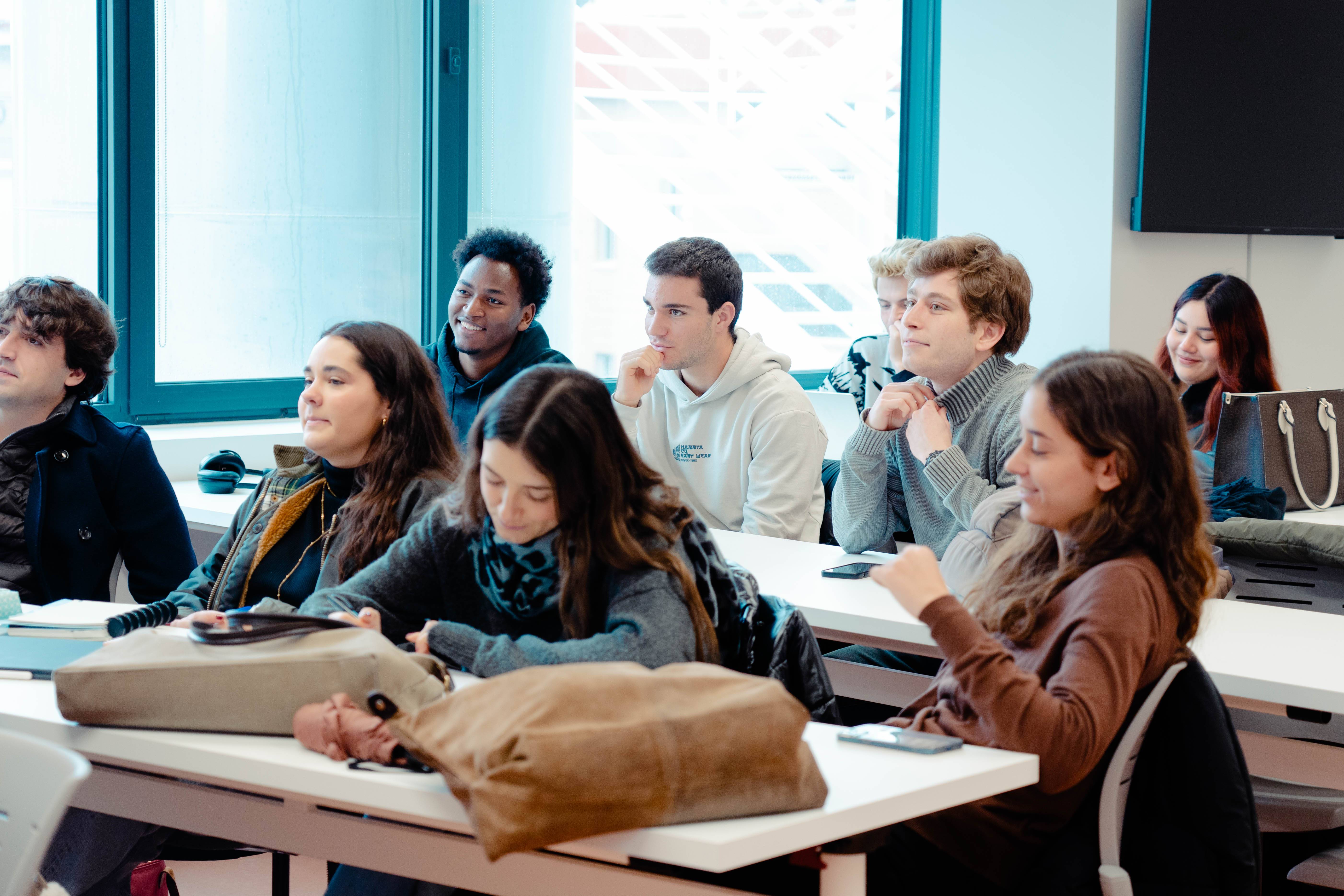 Un grupo de estudiantes prestando atención en un aula moderna.