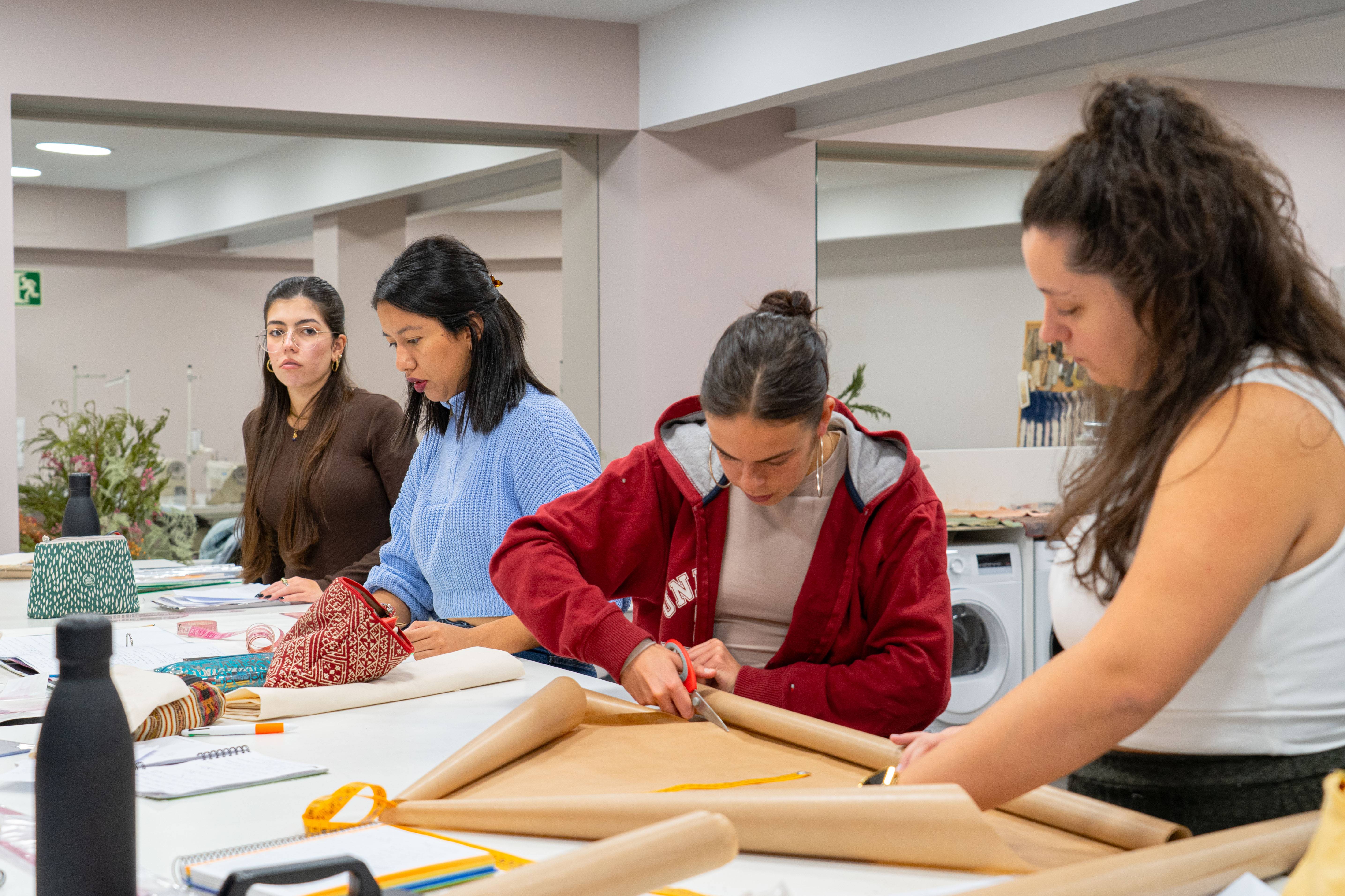 Un grupo de jóvenes mujeres están trabajando en manualidades en una mesa.