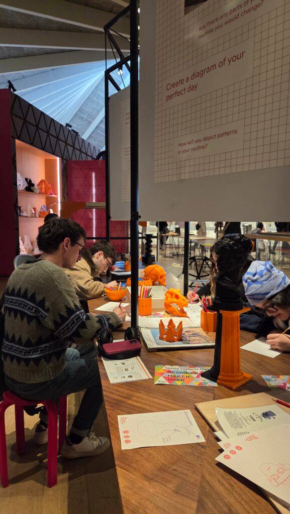 Un grupo de personas trabaja en una actividad creativa en una mesa, rodeados de materiales de arte y decoraciones coloridas.