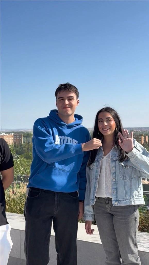 Una pareja de jóvenes sonríe y posa juntos en un día soleado.
