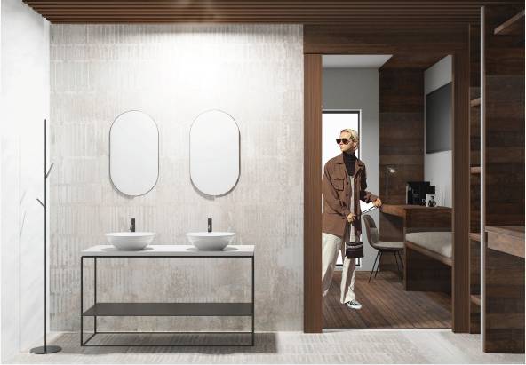Una moderna habitación de baño con dos lavabos y una persona entrando al espacio.