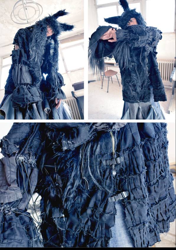 Una persona viste una chaqueta negra con un diseño único y texturizado en un entorno interior.