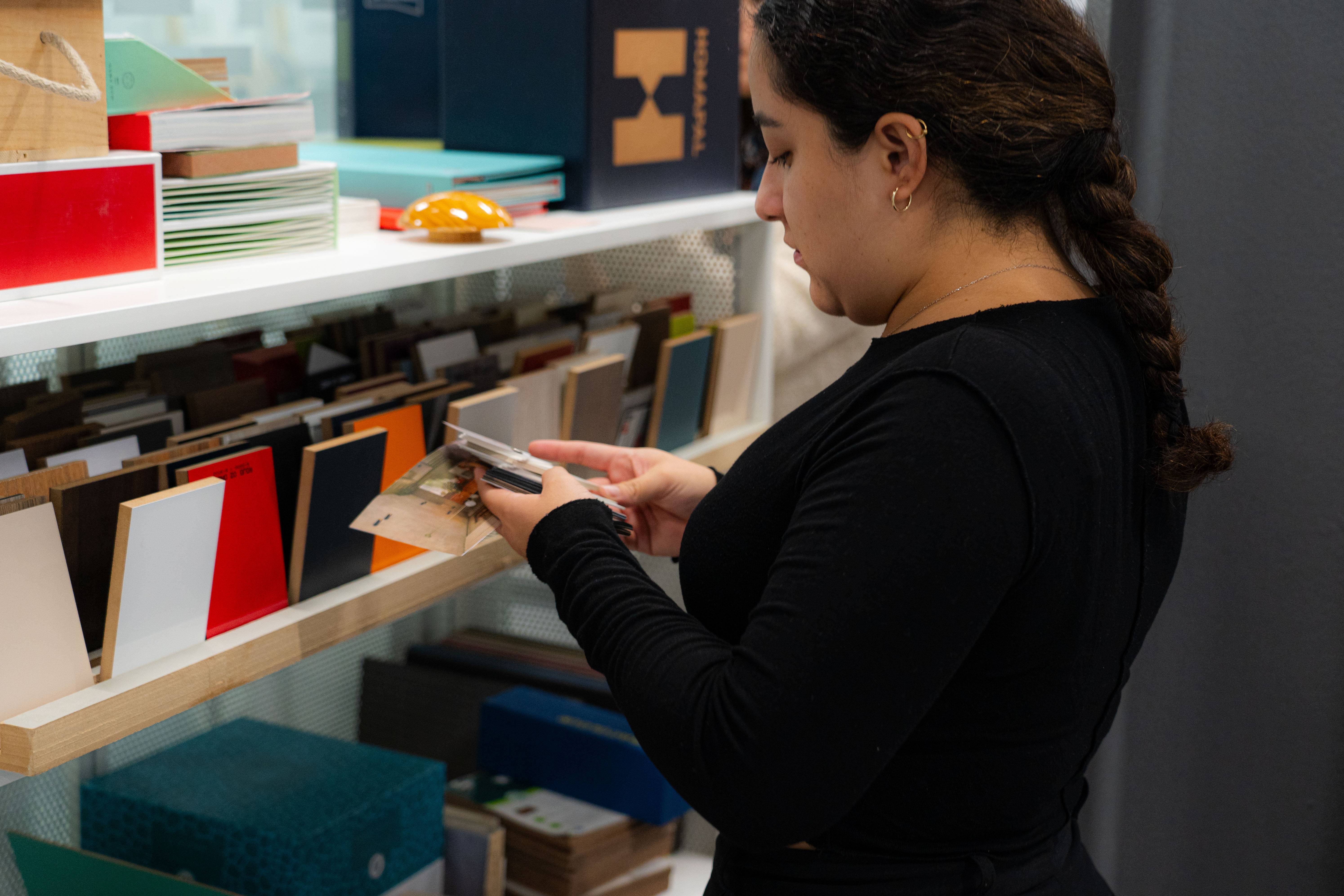 Una mujer revisa una selección de tarjetas y papelería en una tienda.