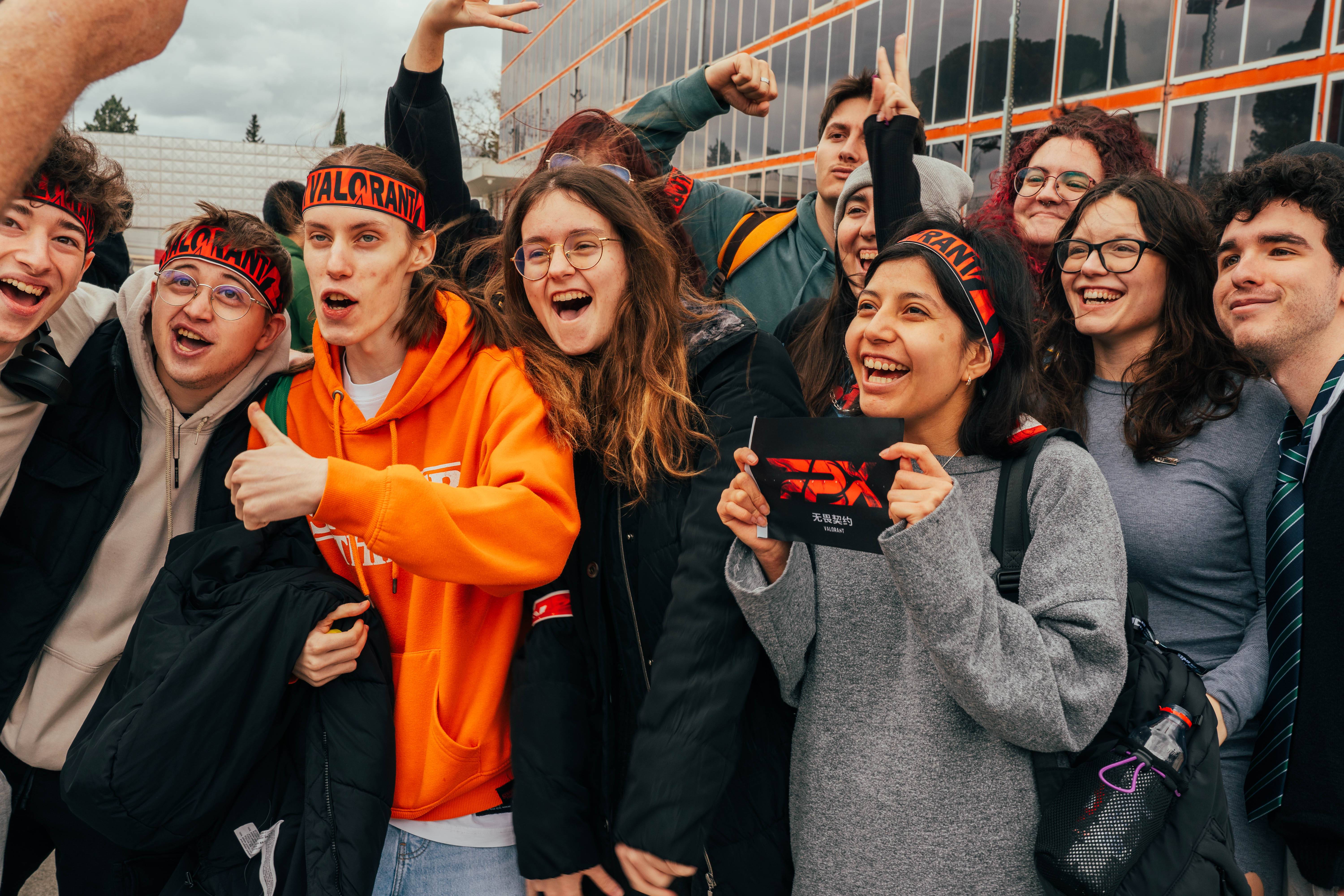 Un grupo de jóvenes sonrientes y emocionados se reúne para tomarse una foto, mostrando alegría y camaradería.