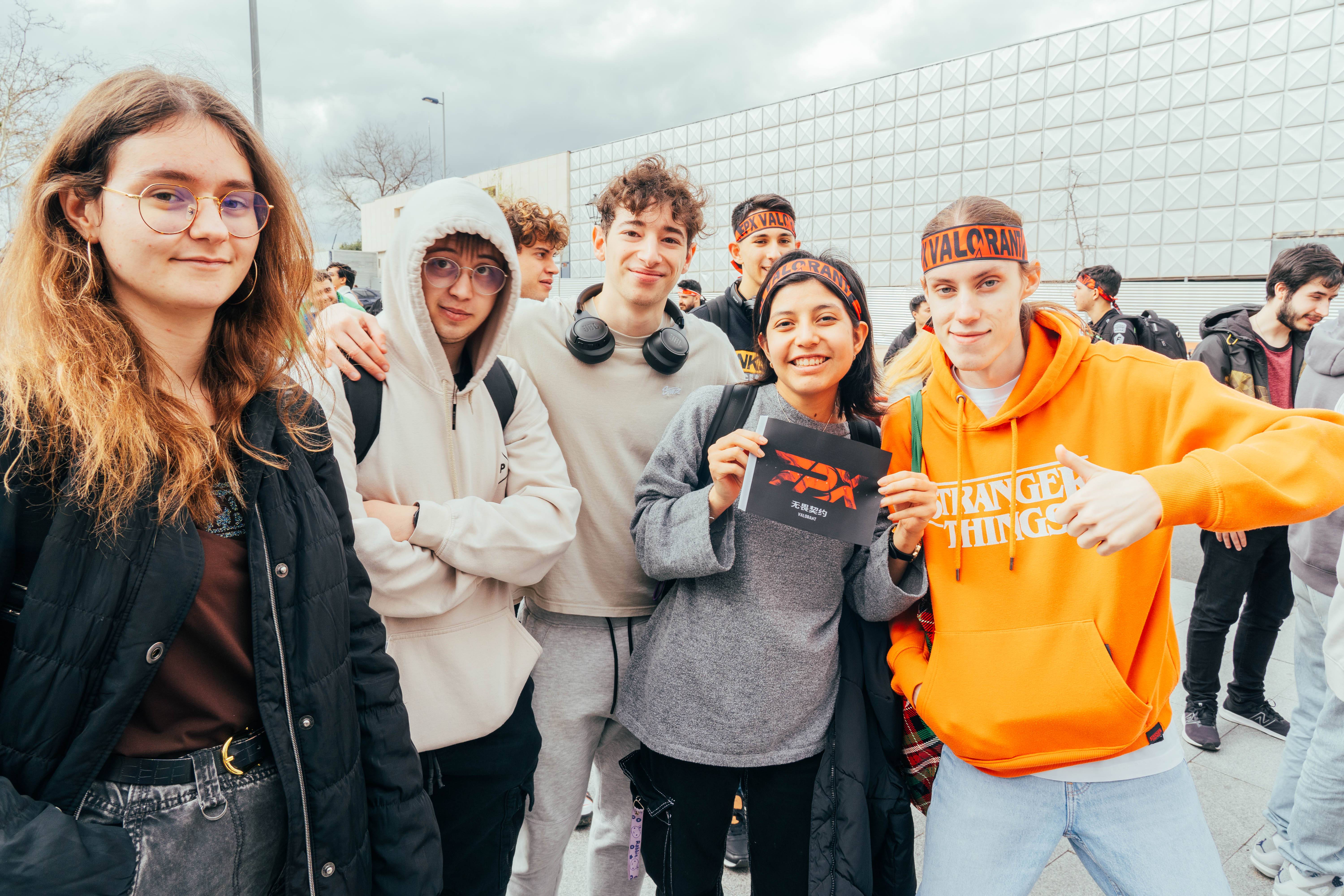 Un grupo de jóvenes sonrientes posando juntos en un evento al aire libre.