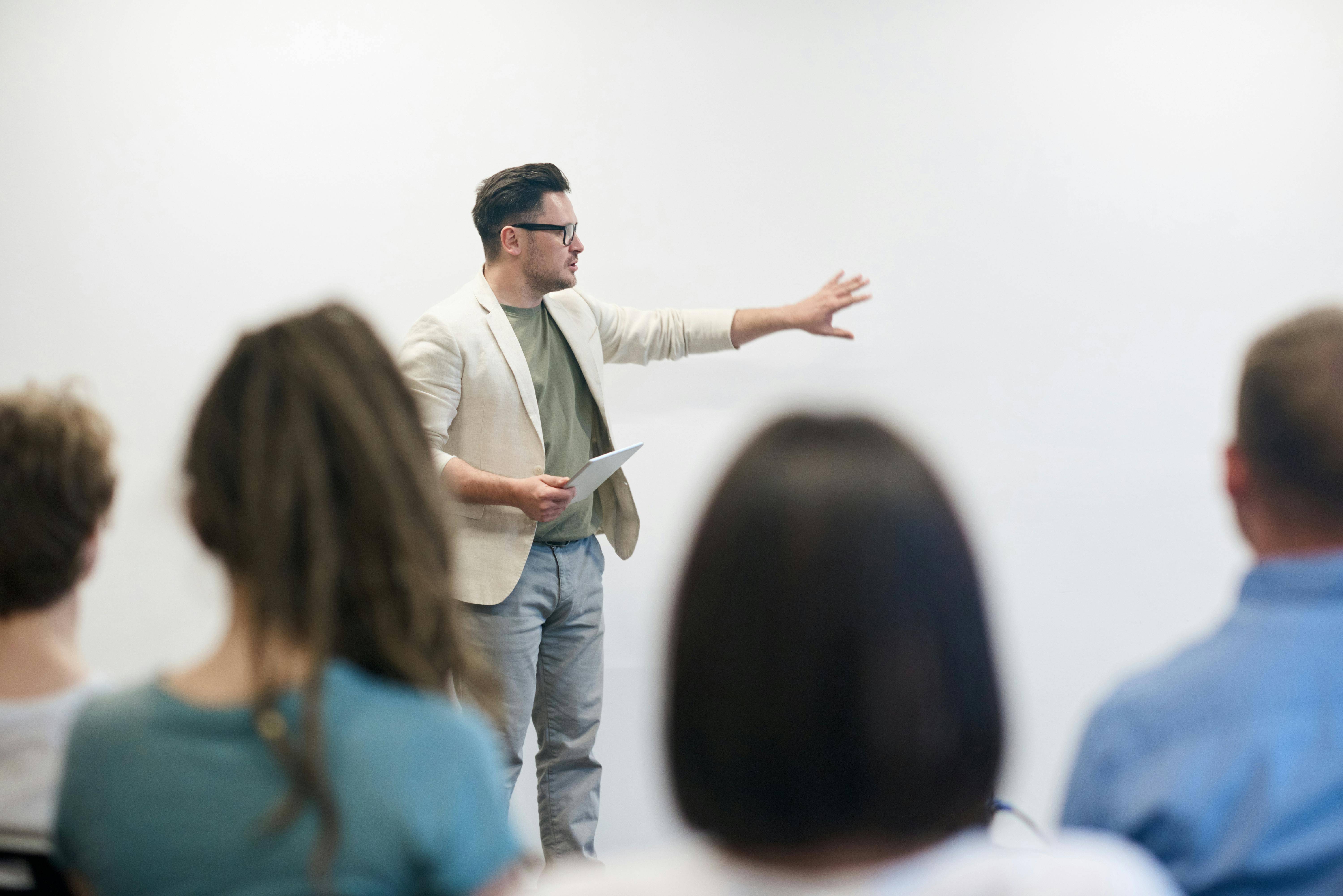 Un hombre está dando una presentación frente a un grupo de personas en un entorno profesional.