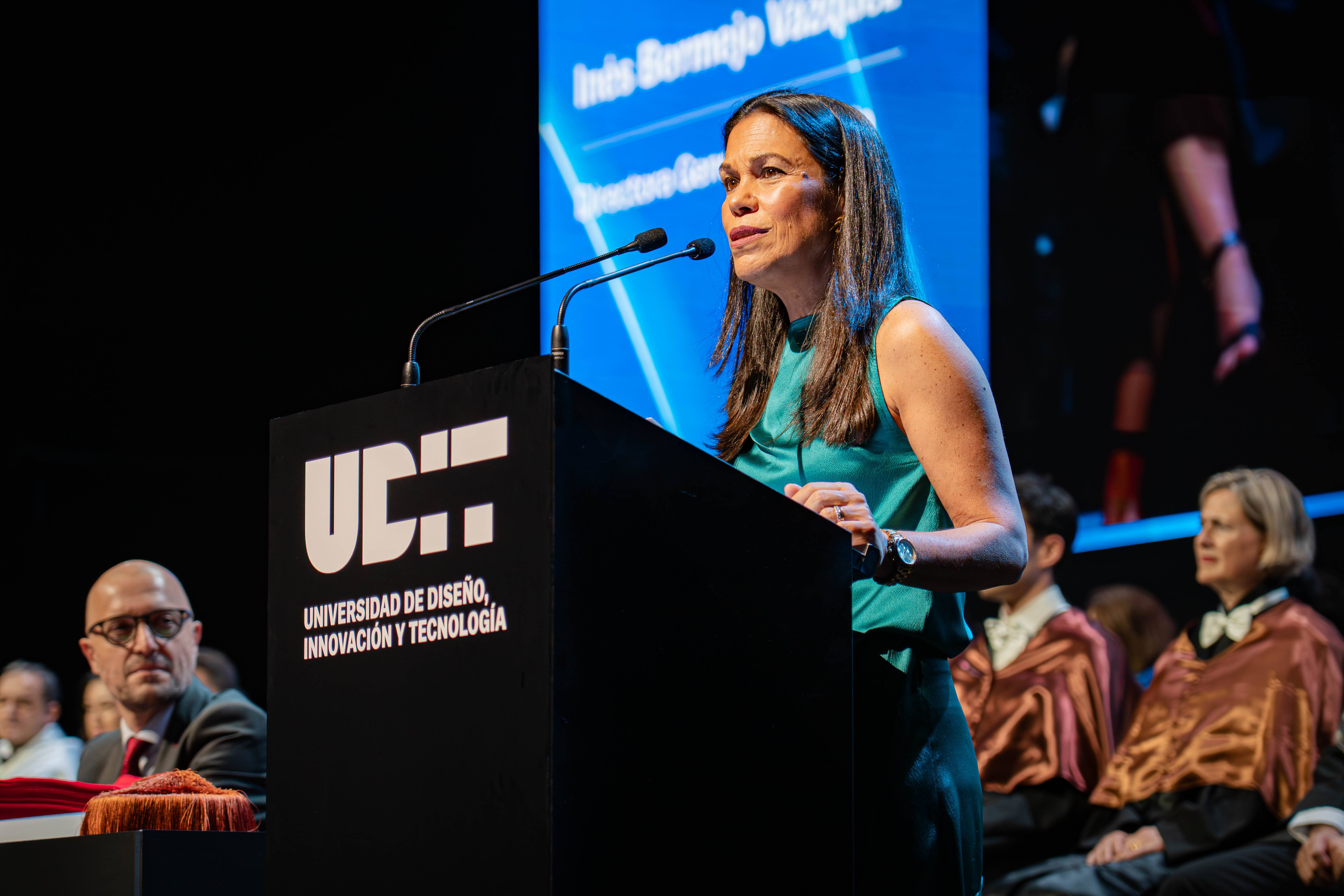 Una mujer habla desde un estrado en un evento académico en la Universidad de Diseño, Innovación y Tecnología.