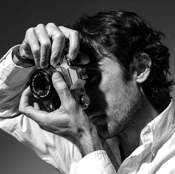 Un hombre está tomando una fotografía con una cámara en blanco y negro.