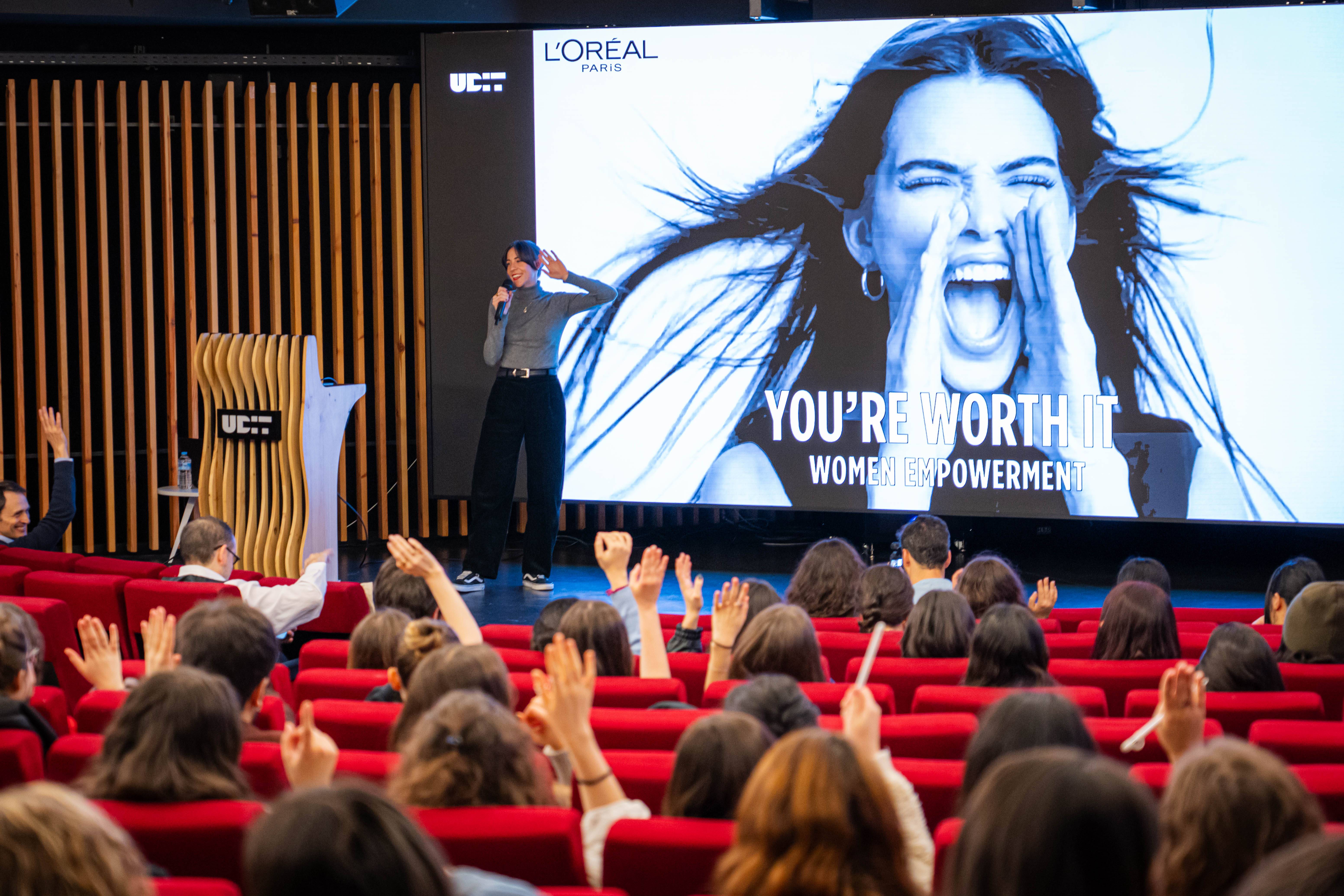 Una presentación sobre el empoderamiento femenino en un auditorio lleno de mujeres.