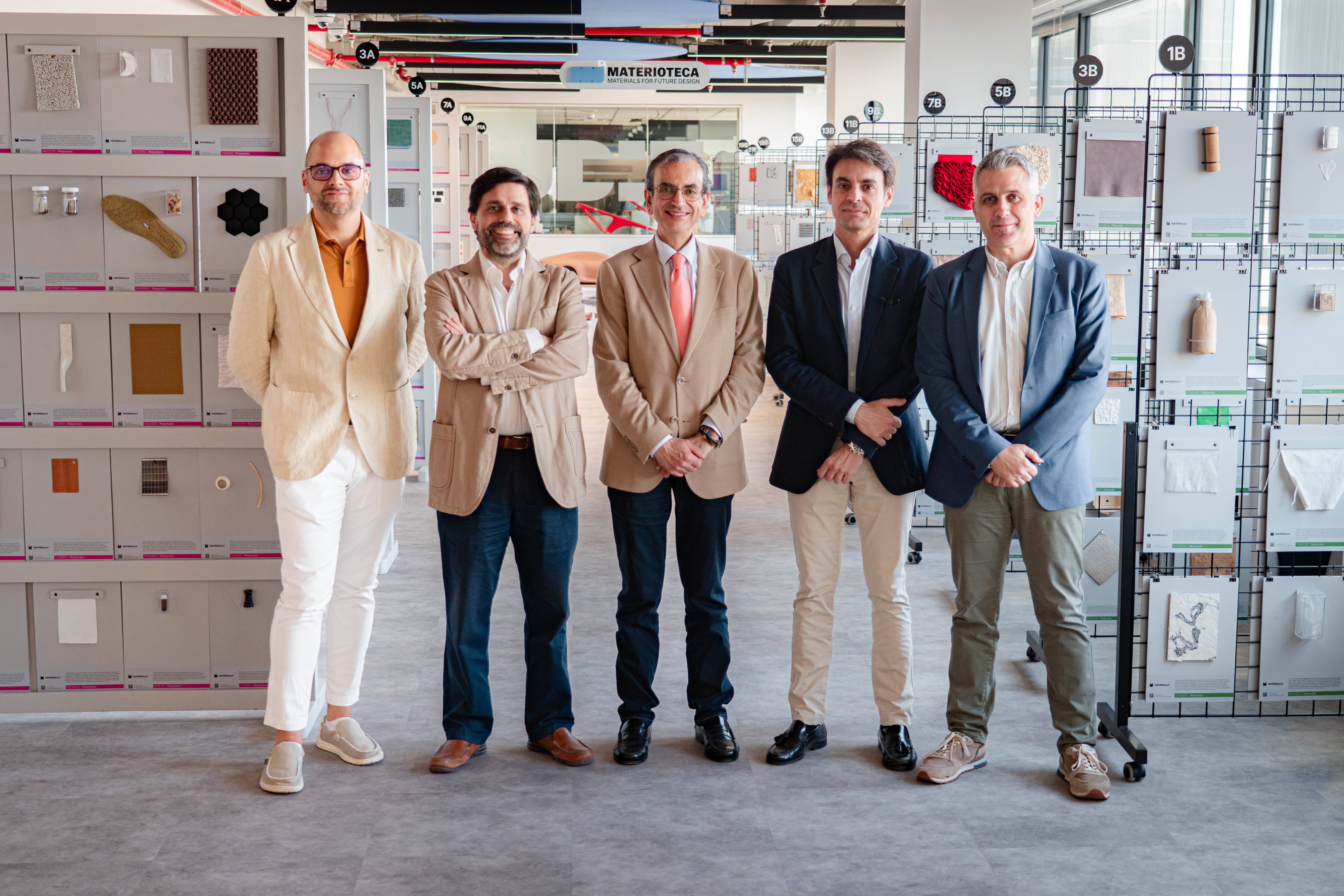 Grupo de cinco personas posando en un entorno moderno rodeado de muestras de materiales.