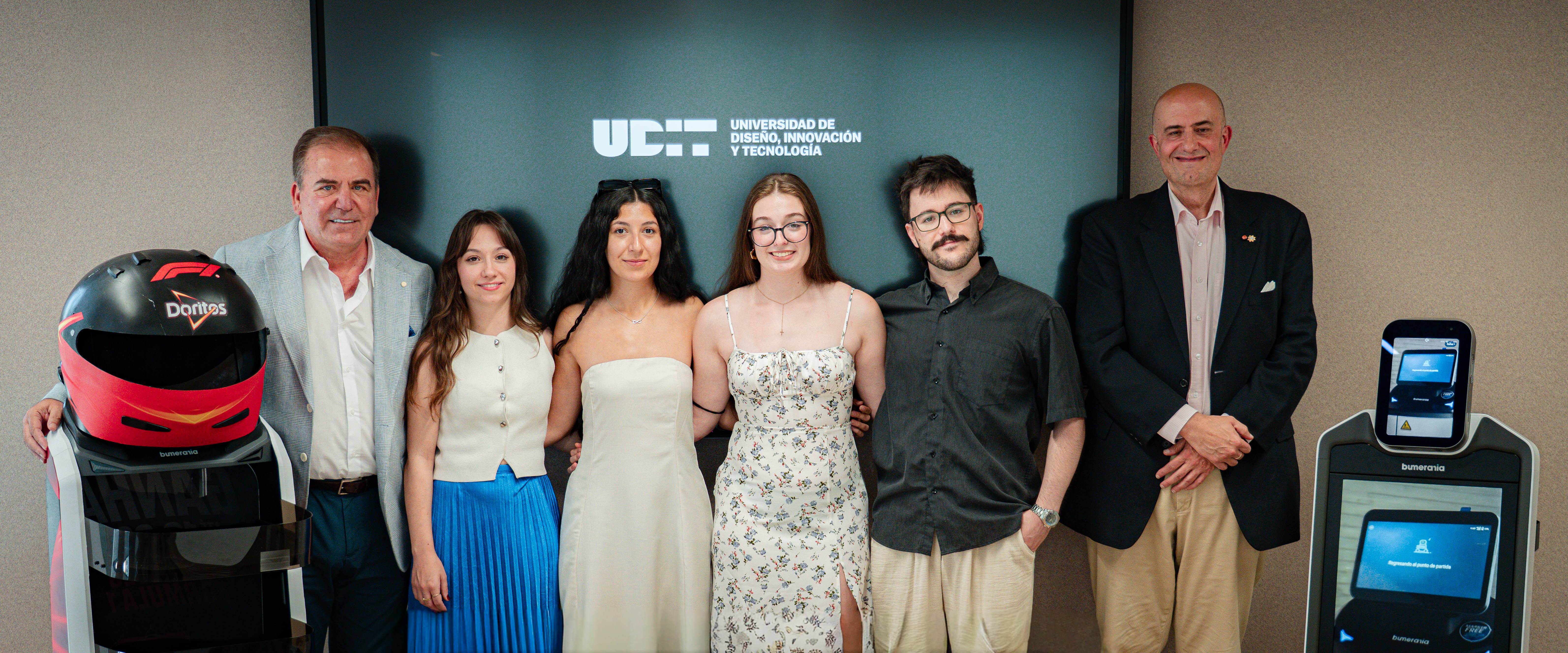 Un grupo de personas posando frente a una pantalla en un evento relacionado con la tecnología.