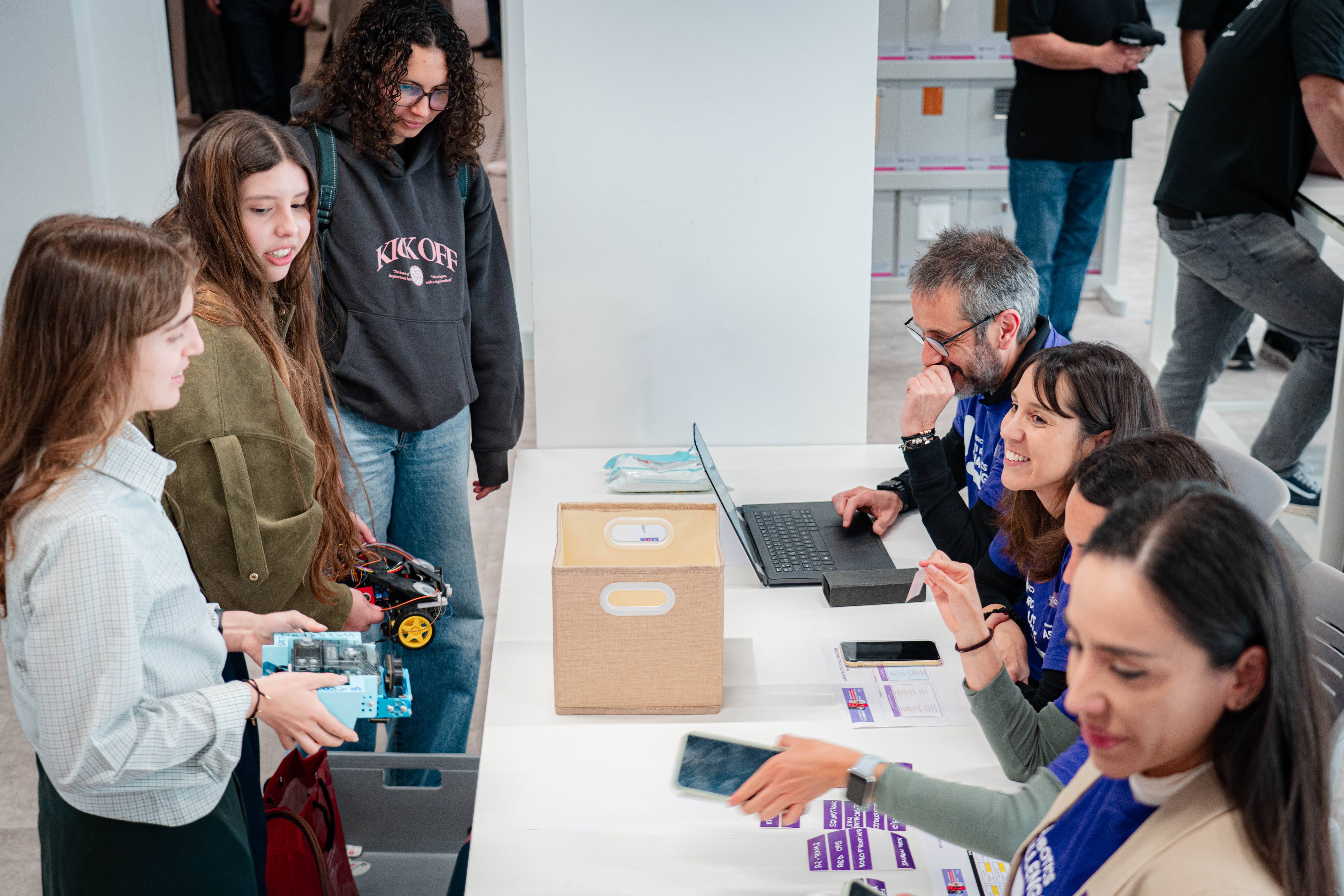 Un grupo de personas interactuando en un evento, con varias actividades y un ambiente colaborativo.