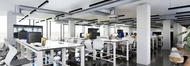 Una moderna oficina con varias mesas de trabajo y computadoras en un ambiente luminoso.