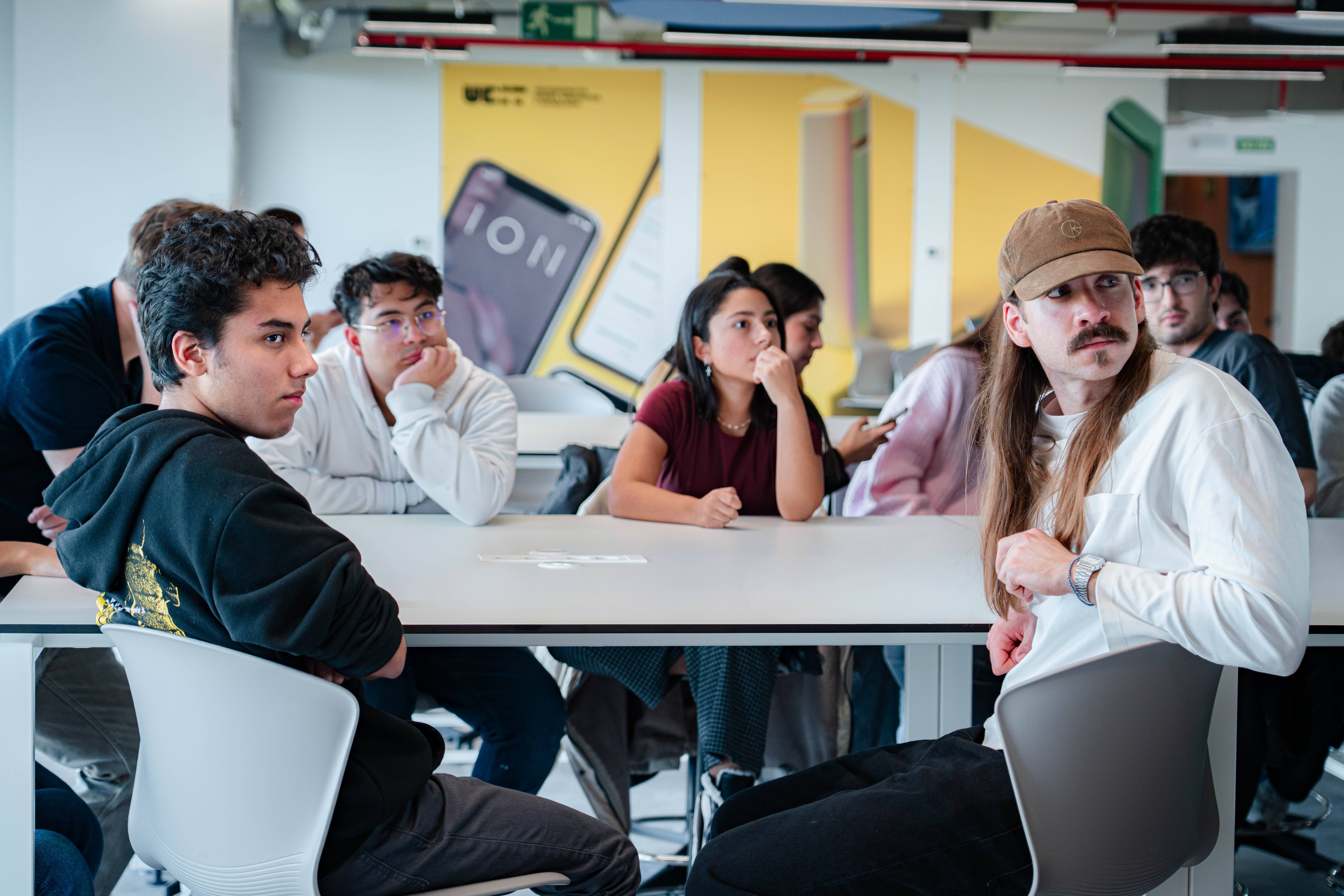 Un grupo de jóvenes prestando atención en un aula moderna.