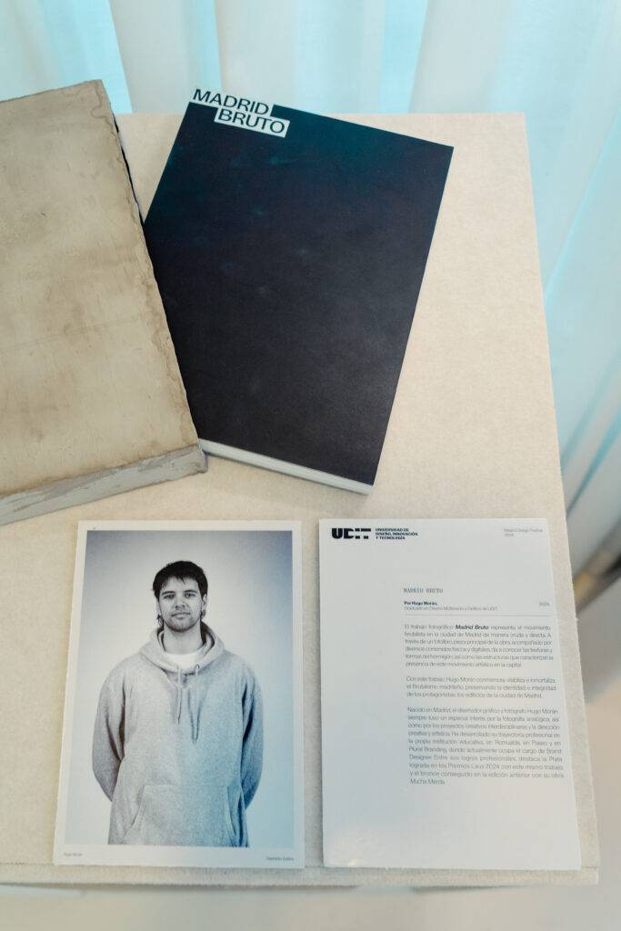 Una mesa con un libro titulado 'Madrid Bruto', una fotografía de una persona y un documento escrito encima.