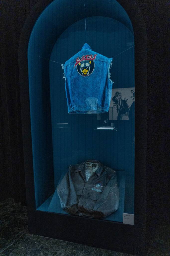 Una vitrina exhibe una chaqueta de mezclilla y un chaleco azul con un logo distintivo de un gato.