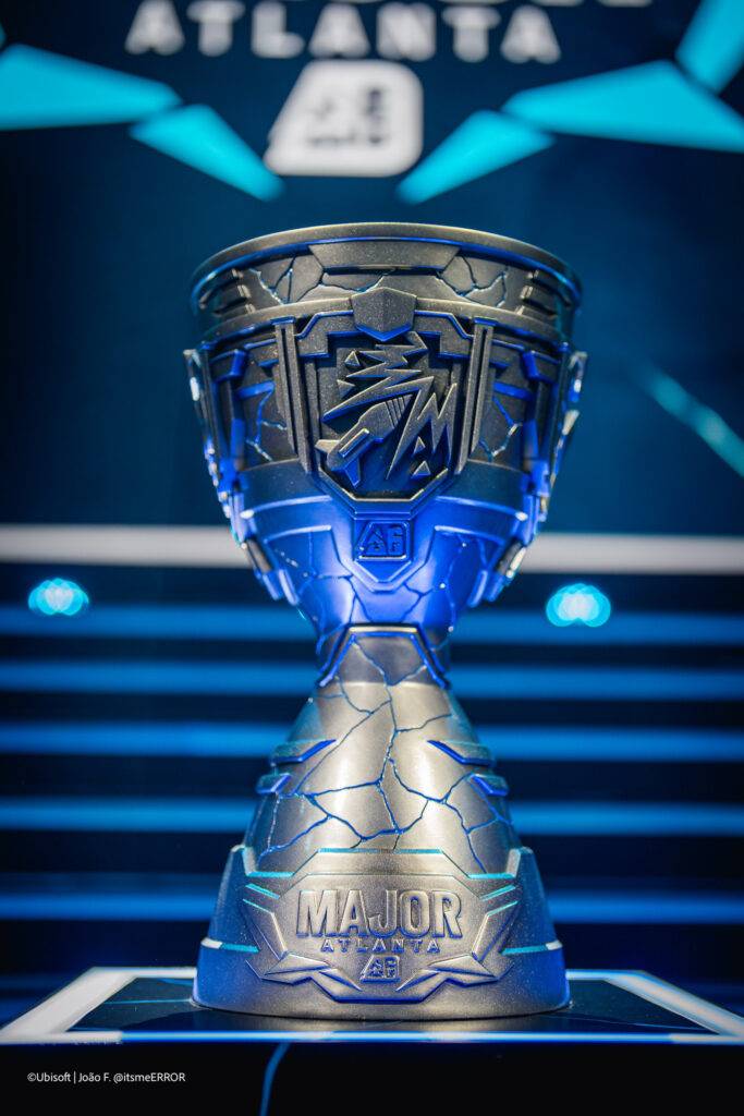Una imagen de un trofeo brillante con un diseño angular en un escenario iluminado.