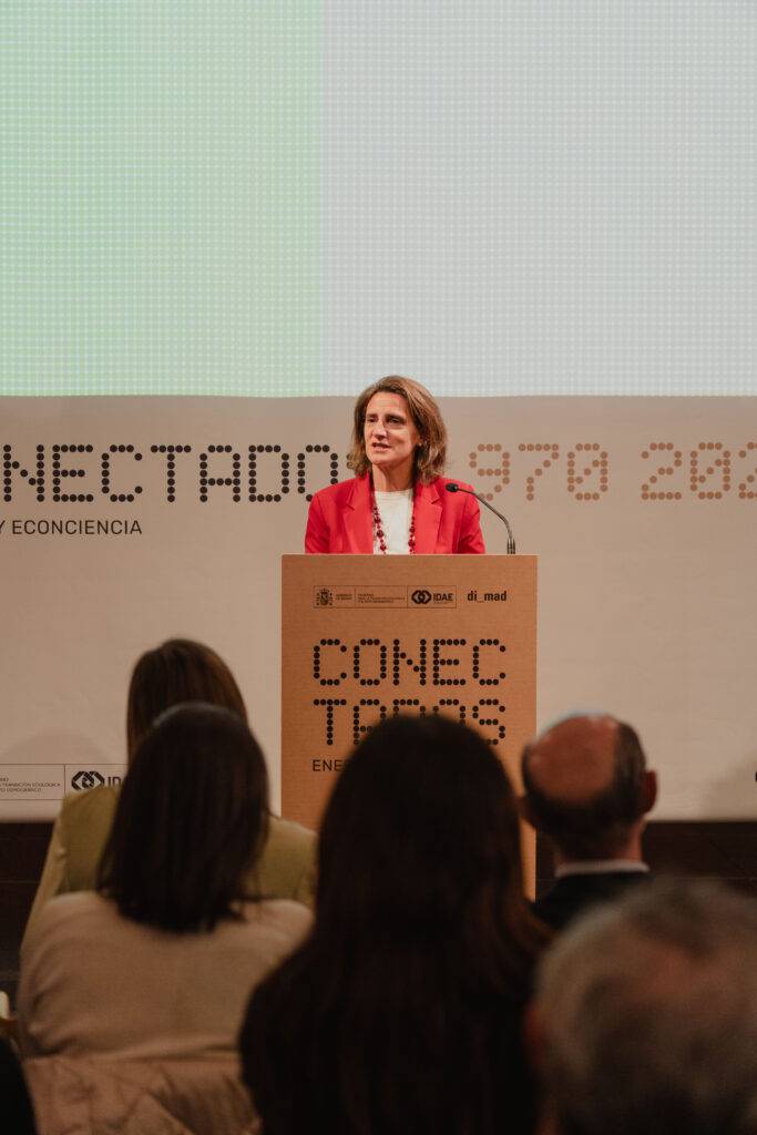 Una mujer habla desde un podio en un evento relacionado con la economía y la tecnología.