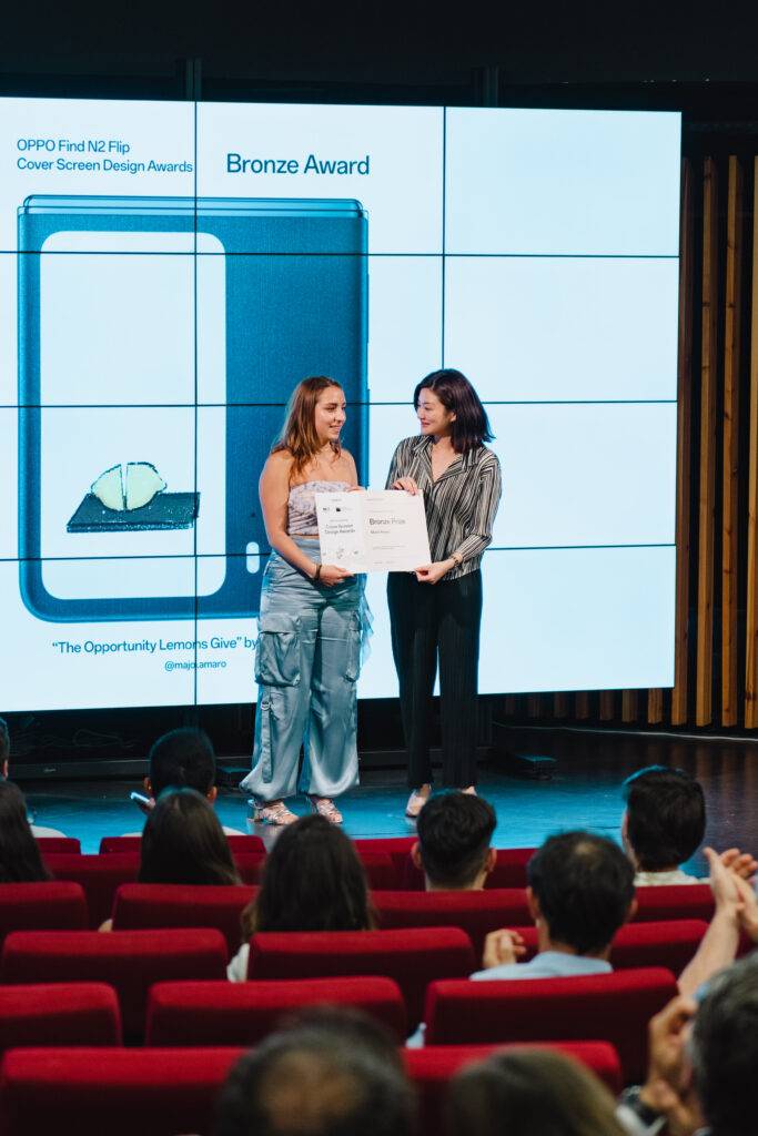 Una mujer recibe un premio de bronce durante una ceremonia de entrega.