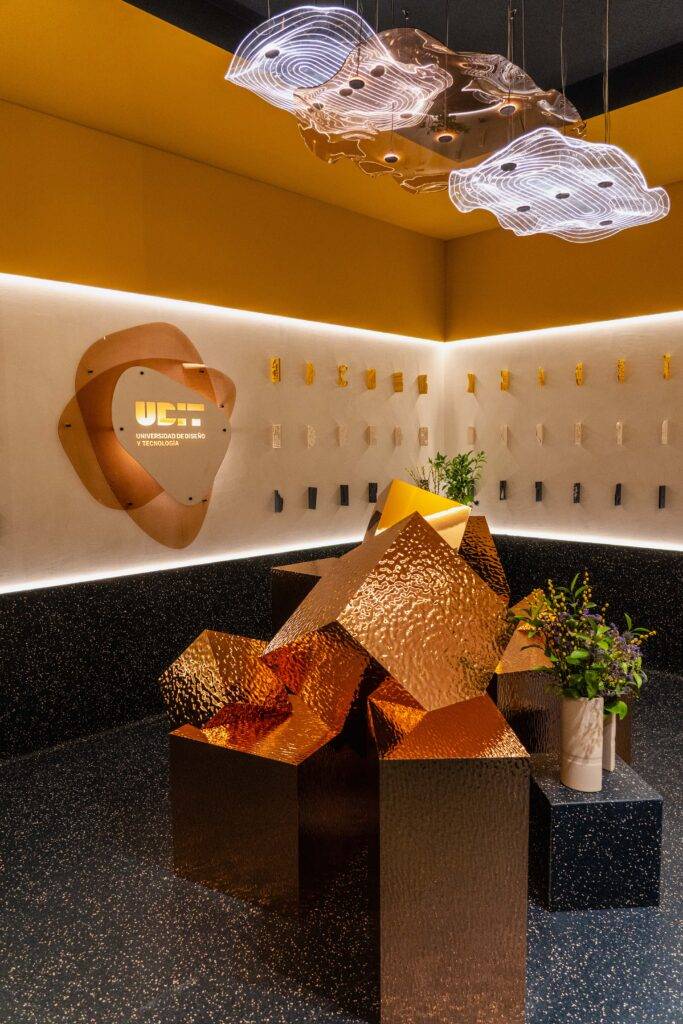 Una moderna exhibición con formas arquitectónicas en tonos metálicos y decoraciones florales.