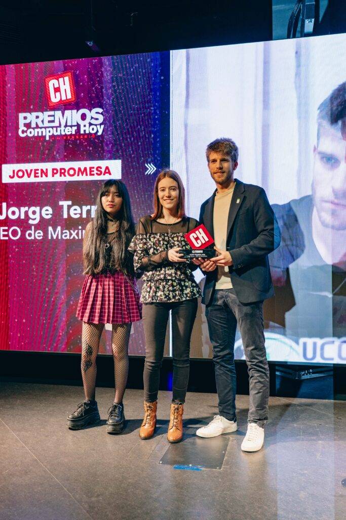 Tres personas posan en un evento de premios.