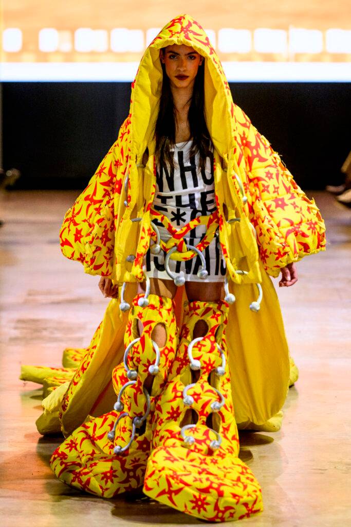Una modelo presenta un atuendo llamativo y colorido en una pasarela.