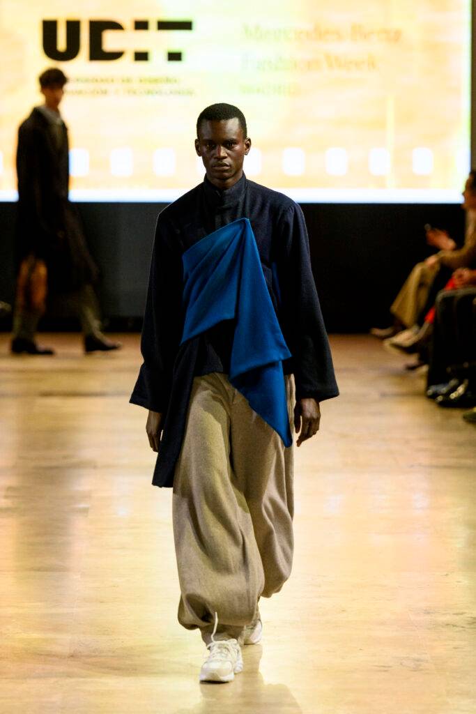 Un modelo camina por la pasarela con un atuendo moderno durante una semana de la moda.