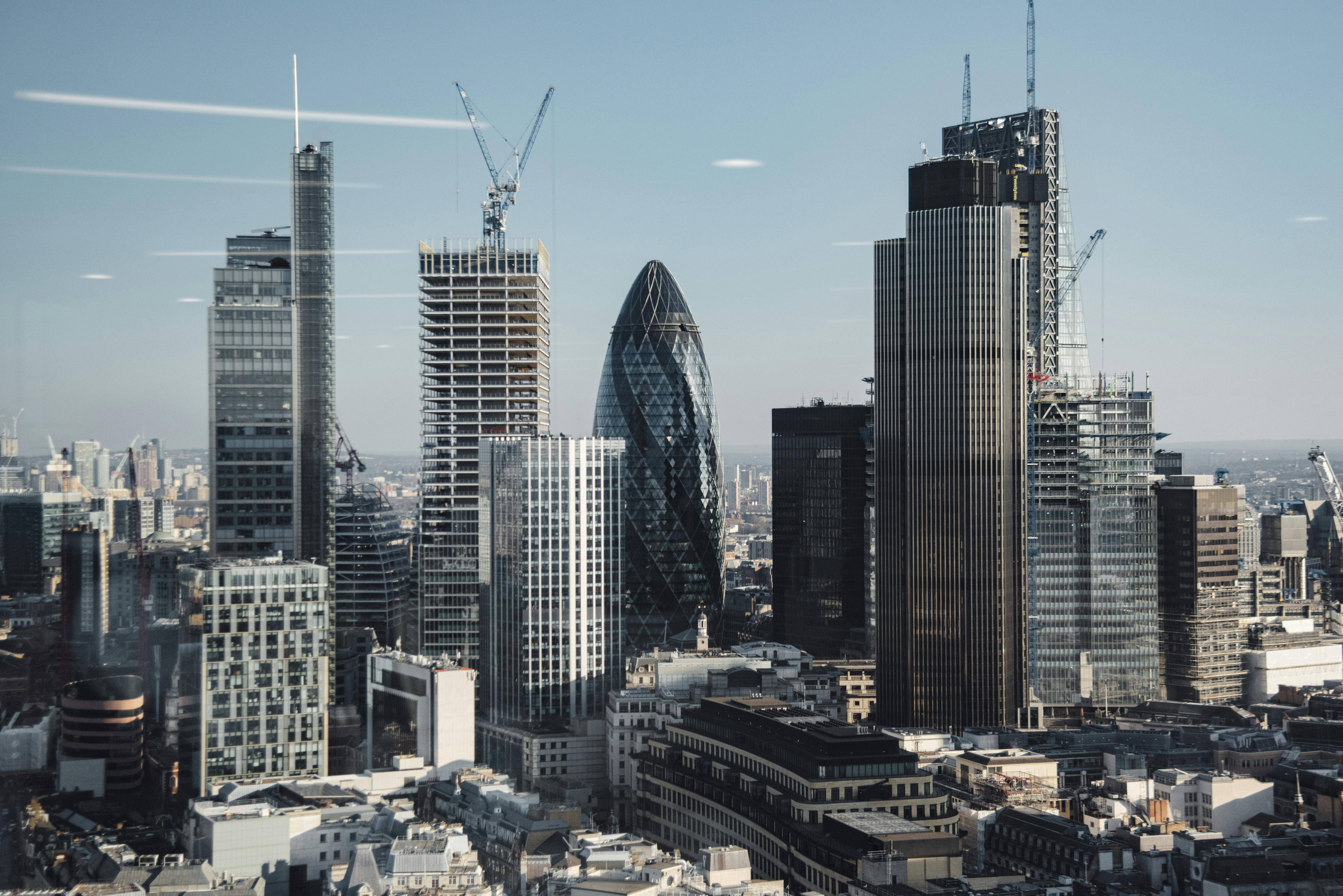 Vista panorámica de un paisaje urbano con modernos rascacielos y grúas en construcción.