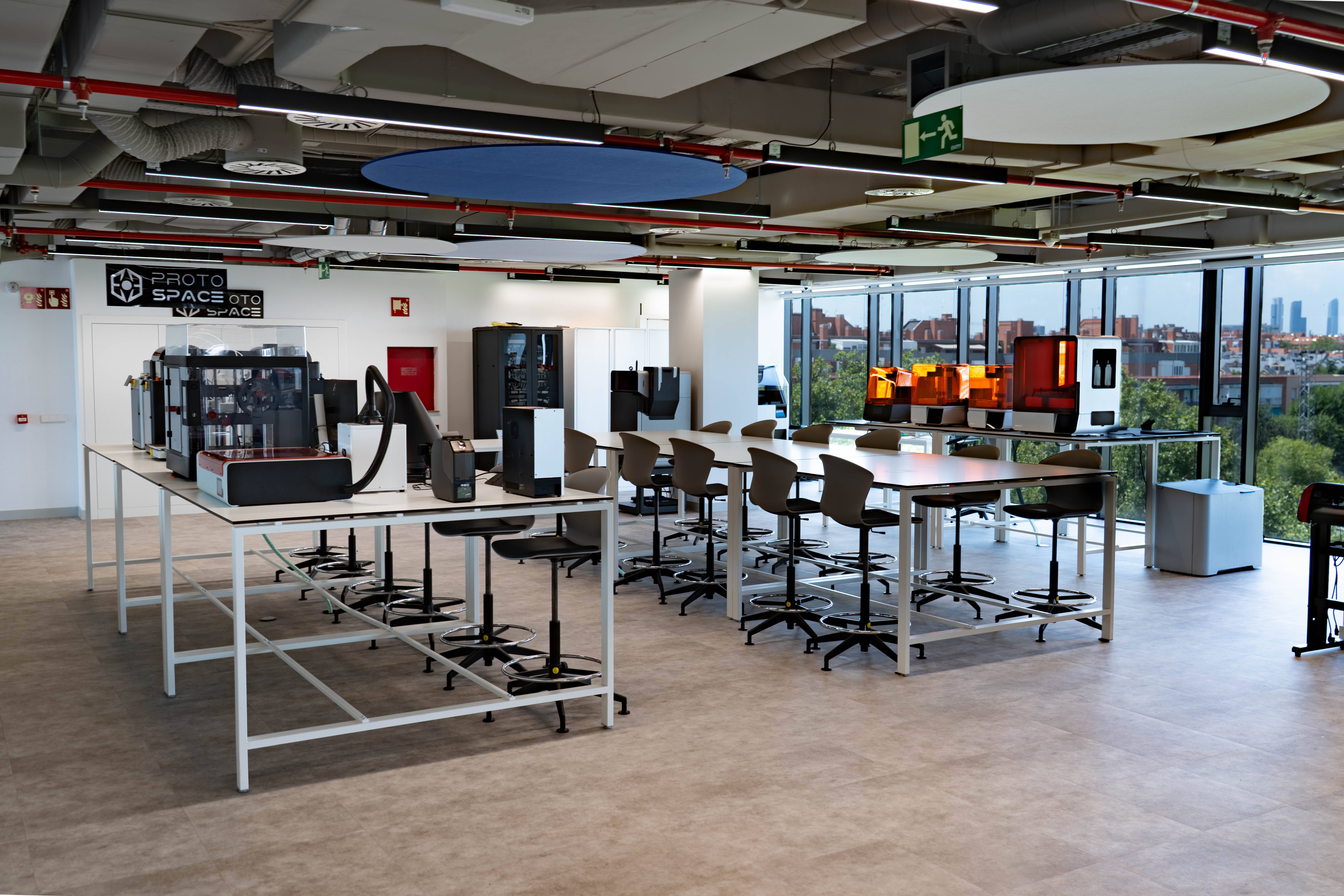 El interior de un espacio de trabajo creativo con mesas y sillas modernas.