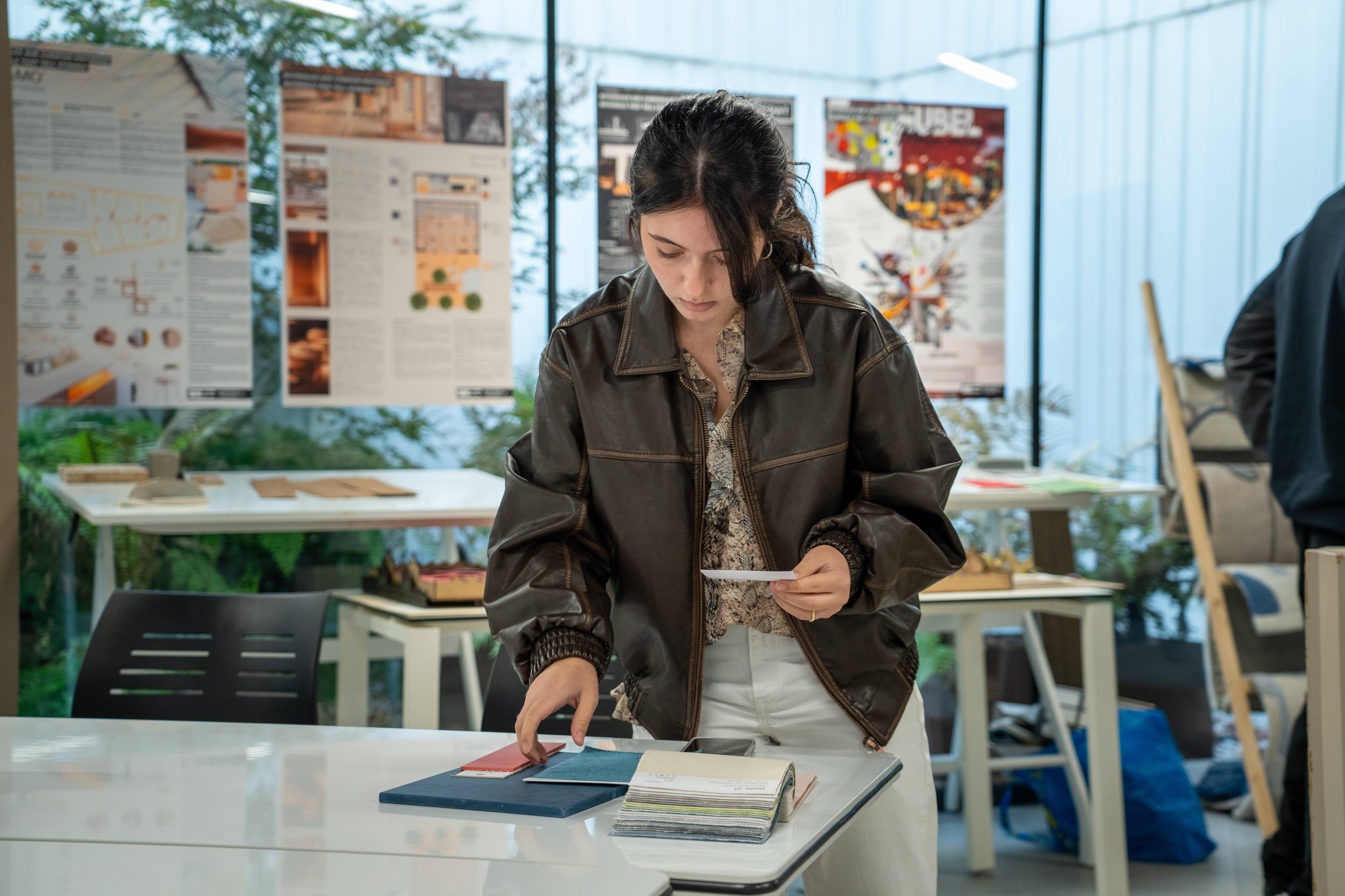 Una joven está revisando algunos documentos en una mesa de estudio en un entorno moderno.