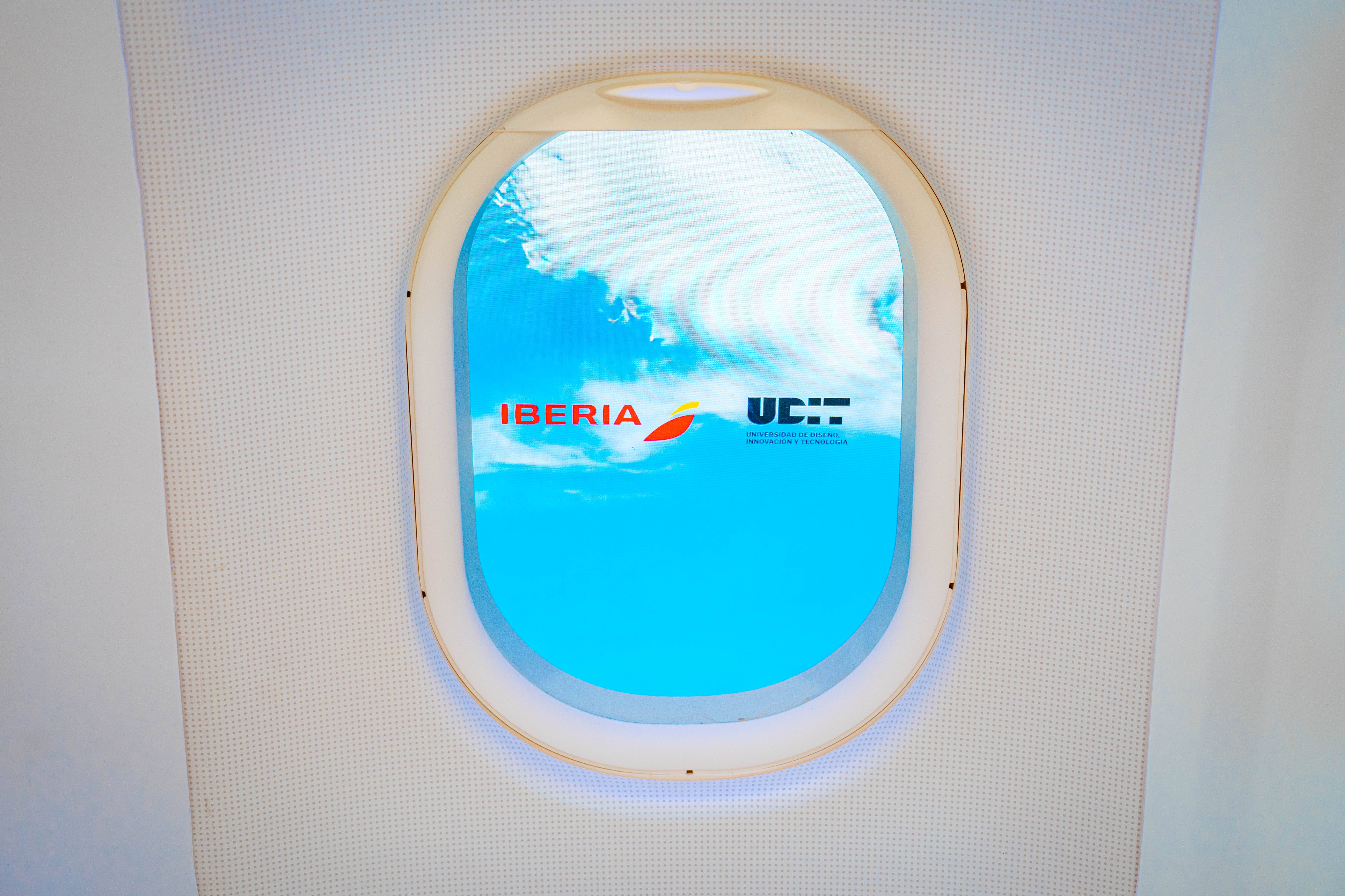 Ventana de avión con vista al cielo y logo de Iberia.