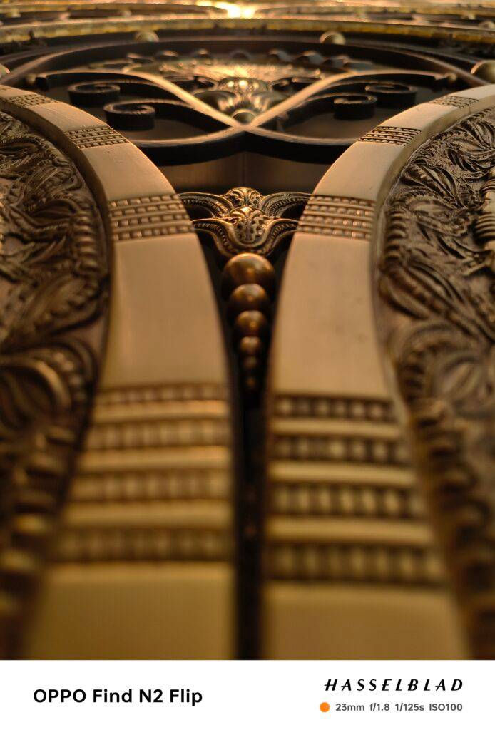 Una imagen en primer plano de un diseño ornamentado en metal dorado.