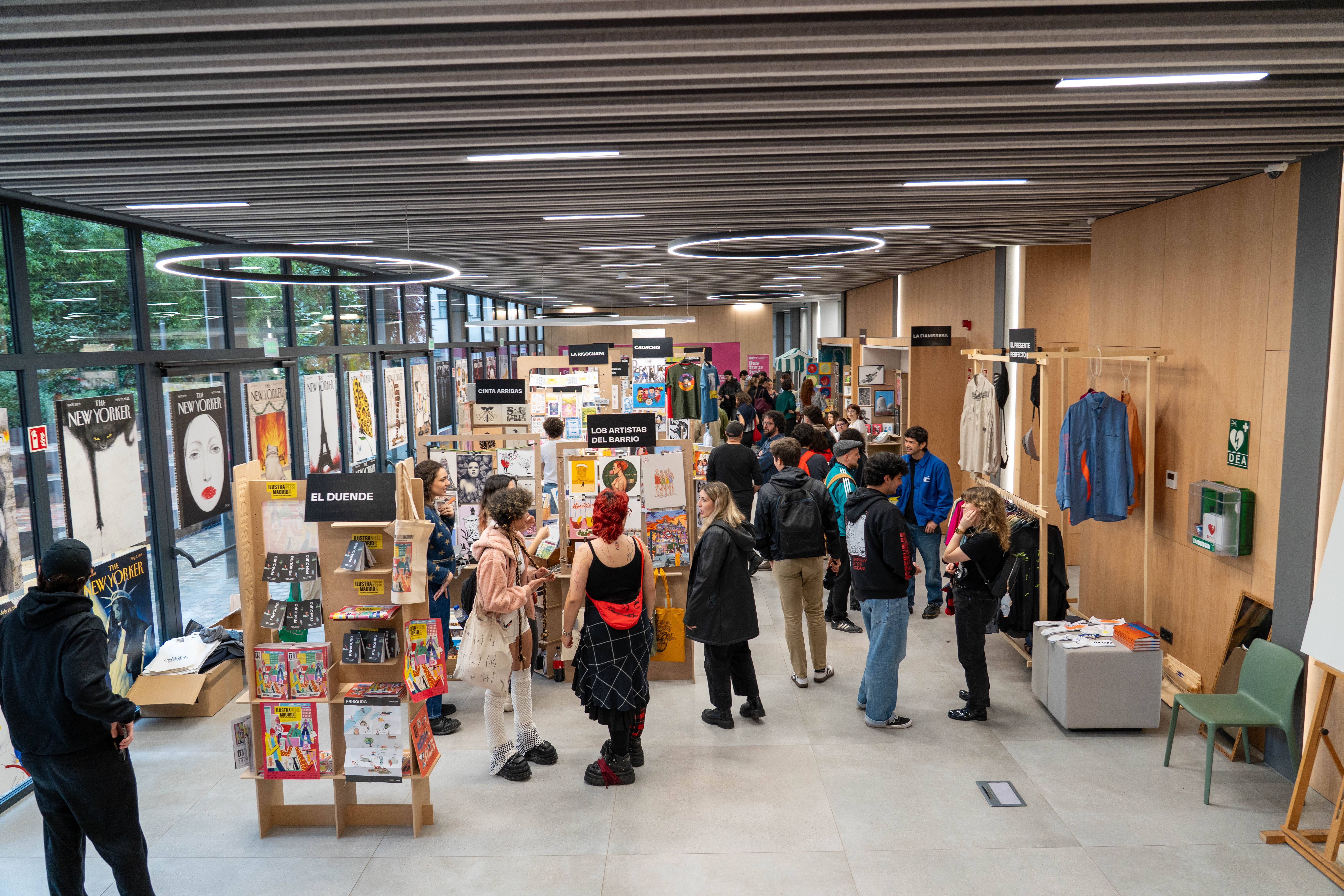 Un evento con muchas personas en un espacio interior que exhibe una variedad de productos artísticos y ropa.