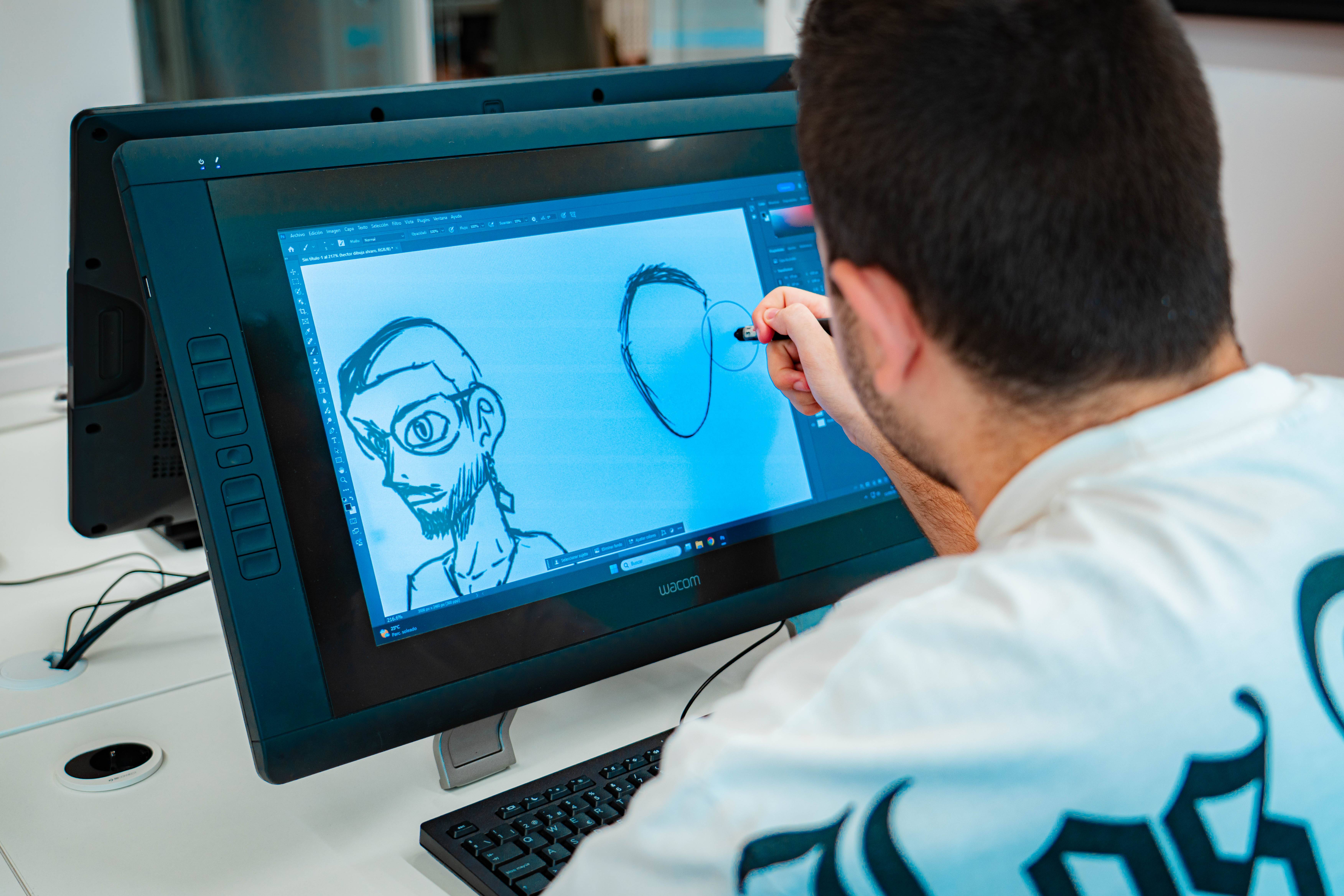 Un artista digital está dibujando en una tableta gráfica mostrando un retrato en proceso.