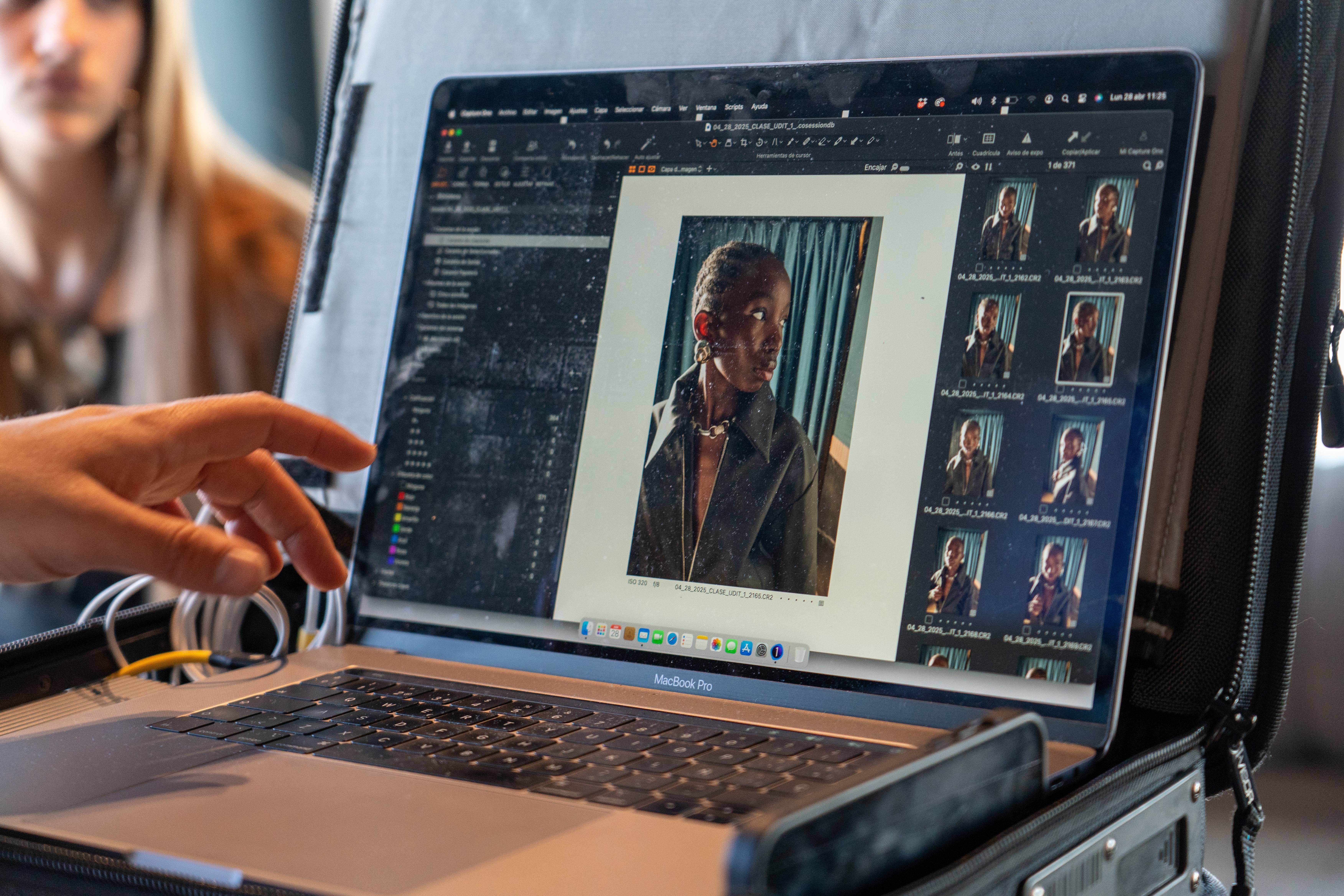 Una persona revisa fotos en una computadora portátil en un entorno artístico.
