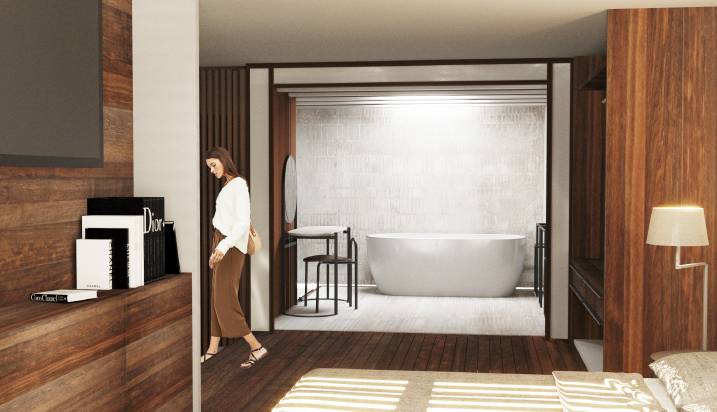 Una mujer camina hacia un baño moderno con una bañera elegante.