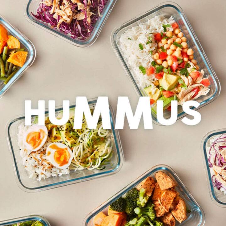 Varias bandejas de comida con diferentes ingredientes y un enfoque central en el hummus.