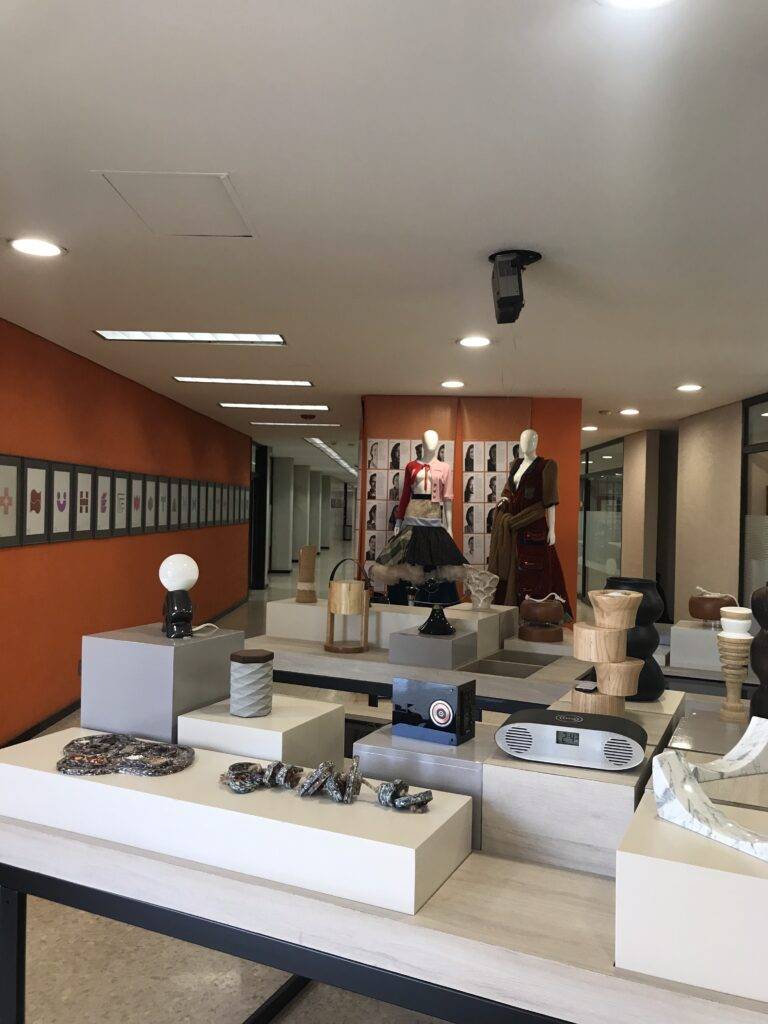 Una boutique moderna con maniquíes exhibiendo ropa y una variedad de accesorios y decoración.