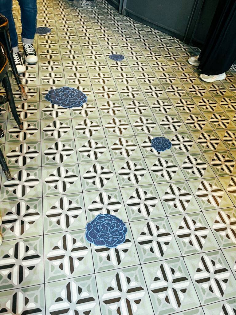 El suelo presenta un diseño decorativo con flores azules y patrones en blanco y negro.